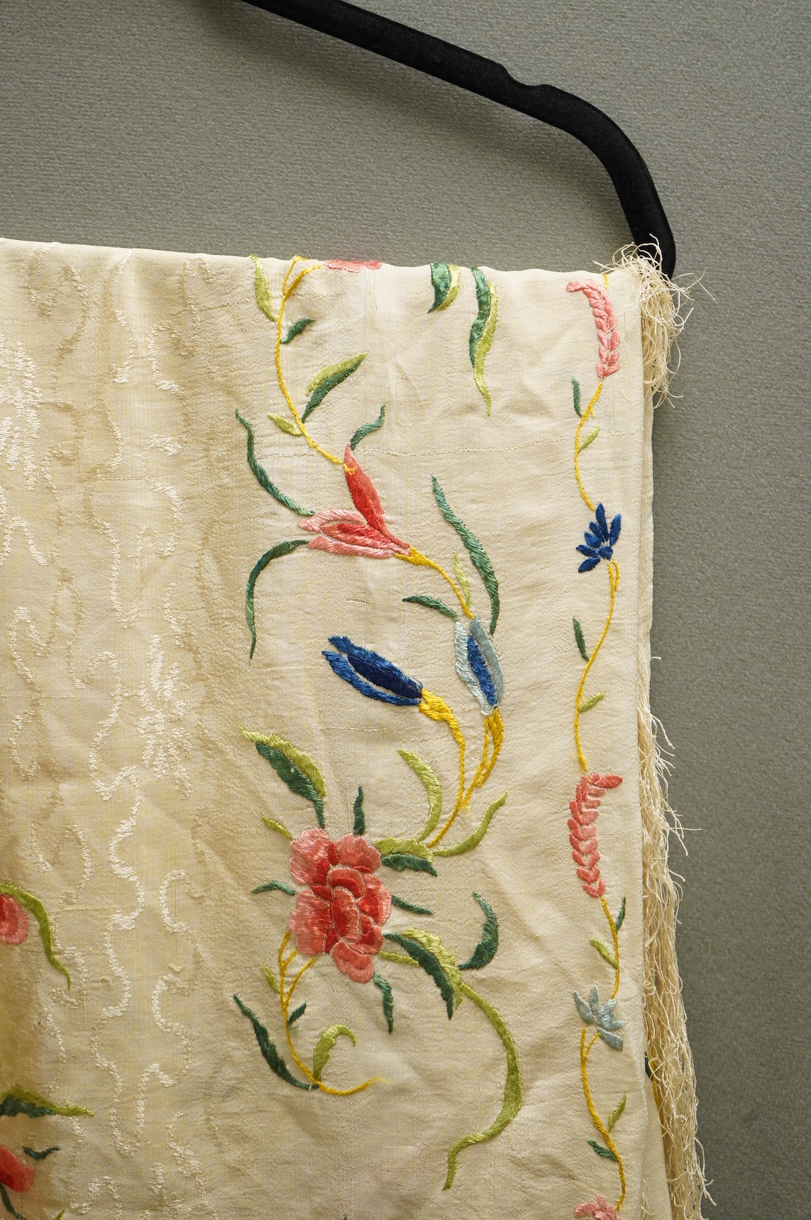 An early Chinese 20th century cream silk damask shawl with a polychrome floral silk embroidered border and a silk fringe, 150cm x 150cm, together with a smaller shawl/scarf, the corner cream on cream embroidered and edgi